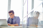 Male employee browsing in laptop